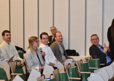 Fabienne Schnieders sitzt im Plenum des Neujahrsempfang, hält Mikrofon und spricht
