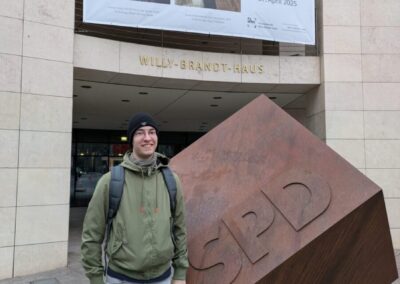 Jakob Becker steht vor dem SPD-Gebäude in Berlin, Metallwürfel mit Schriftzug