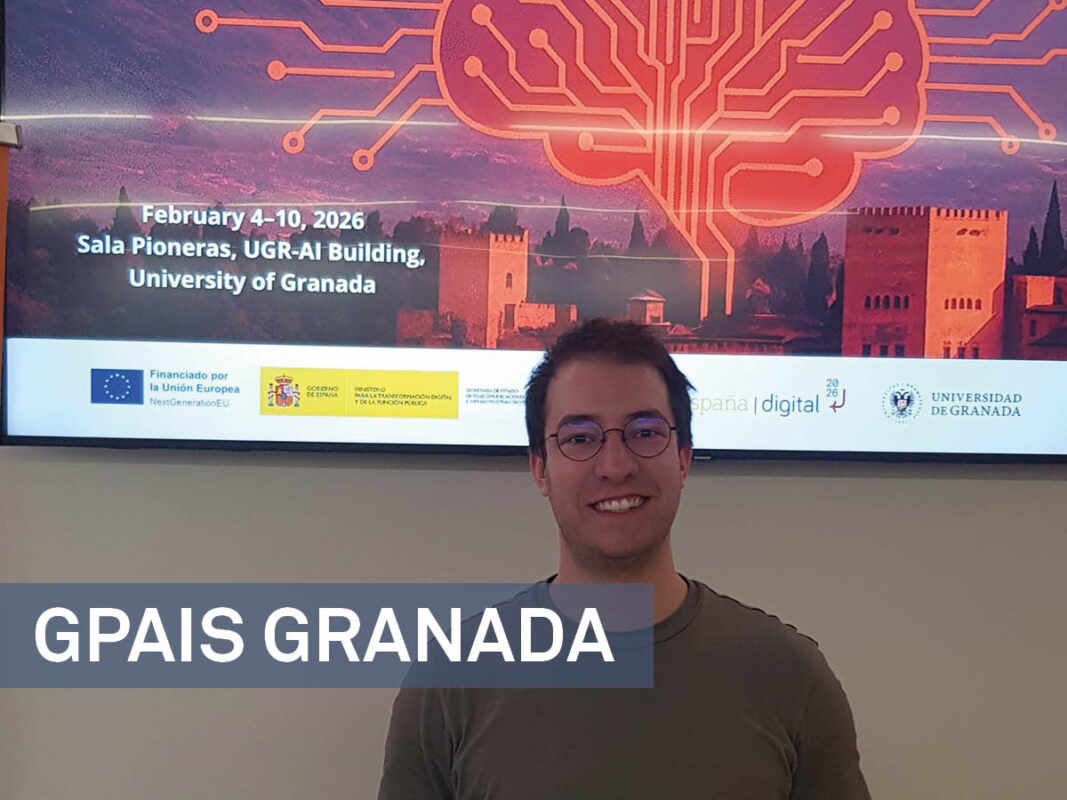 Jakob Becker, Mann mit braunen Haaren und Brille, steht vor einem Beamer-Bilder der GPAIS Winter School in Granada