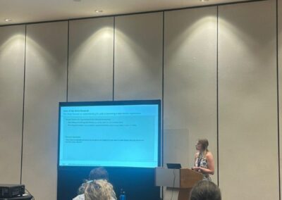 HICSS Konferenz auf Hawaii, Fabienne Schieders steht am Rednerpult und hält Vortrag, Plenum sitzt auf Stühlen