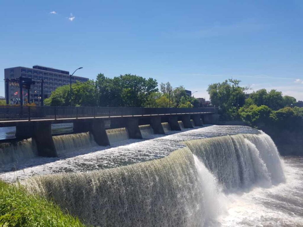 Brücke über Wasserfall in Ottawa, blauer Himmel, Bäume im Hintergrund